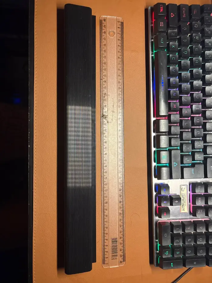 Schwarzer Kabelkanal neben einer Tastatur, Länge mit Lineal verglichen